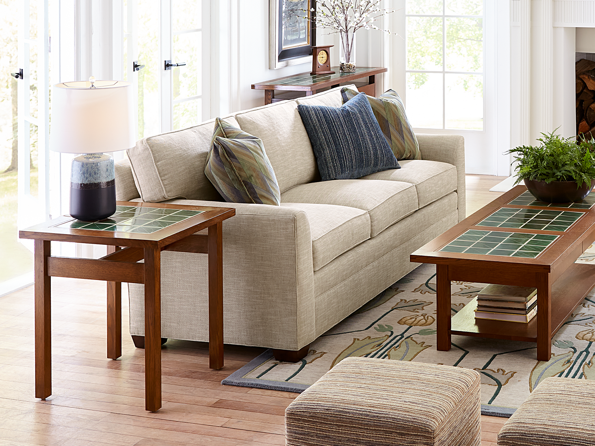 Stickley Fine Upholstery — traditional navy blue leather sofa with nailhead trim and a matching club chair paired with ceramic tile-top accent tables.