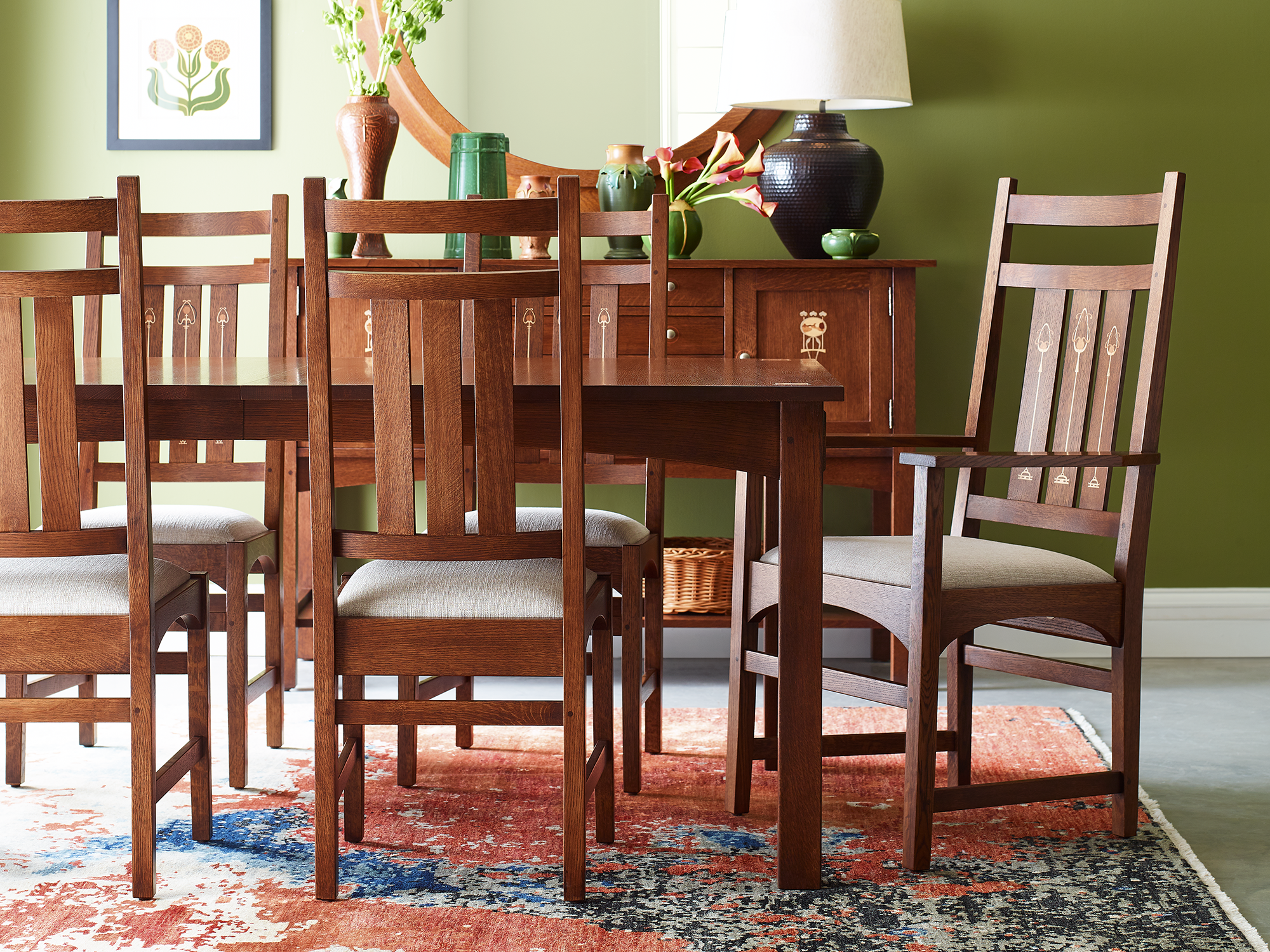 Stickley Harvey Ellis Collection — solid oak dining room set featuring a rectangular table and side chairs with decorative wood-inlay details and arched aprons.