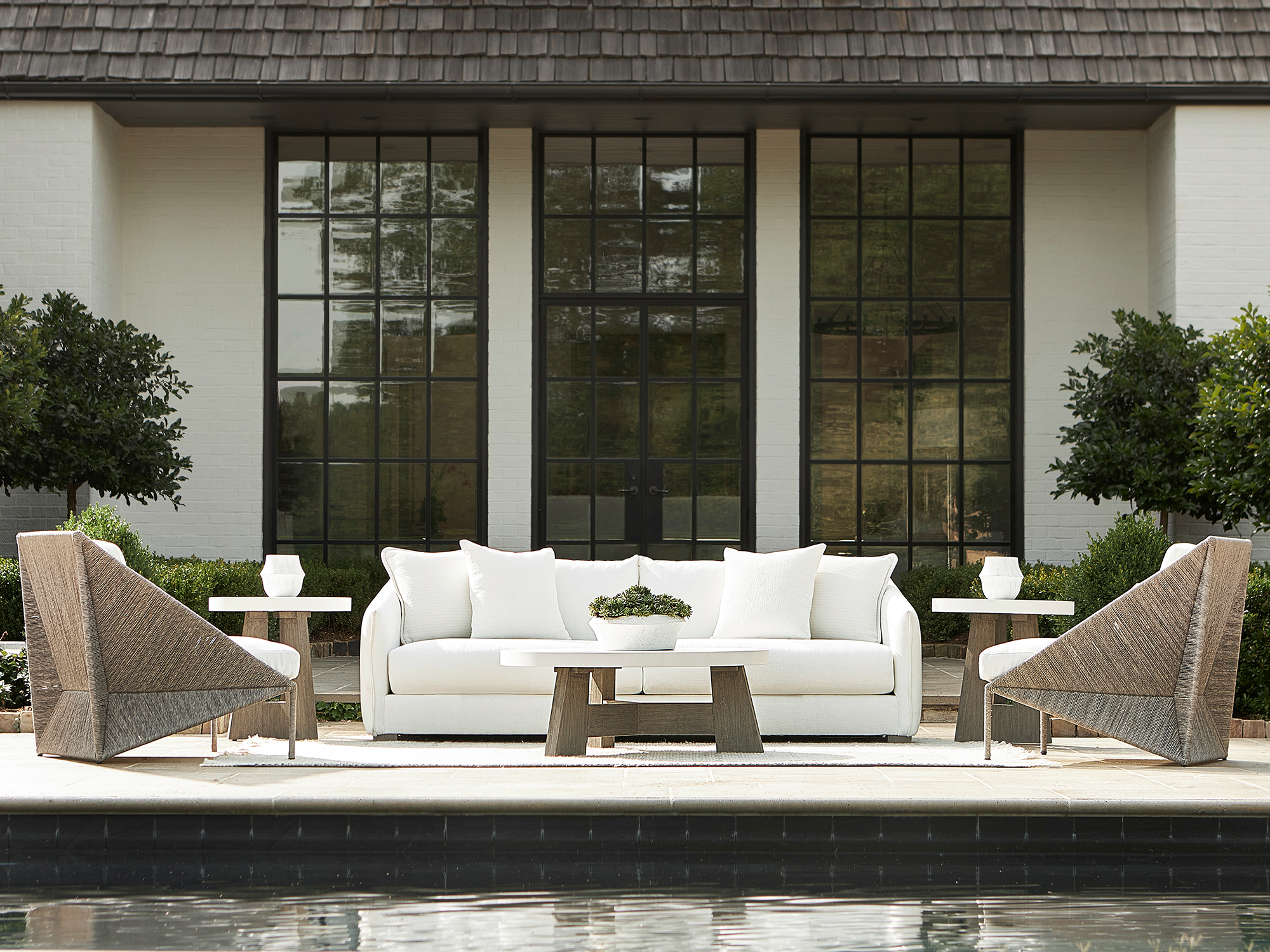 Bernhardt Exteriors — a luxury poolside lounge that brings indoor sophistication to an outdoor setting, defined by crisp contrasts and architectural shapes.