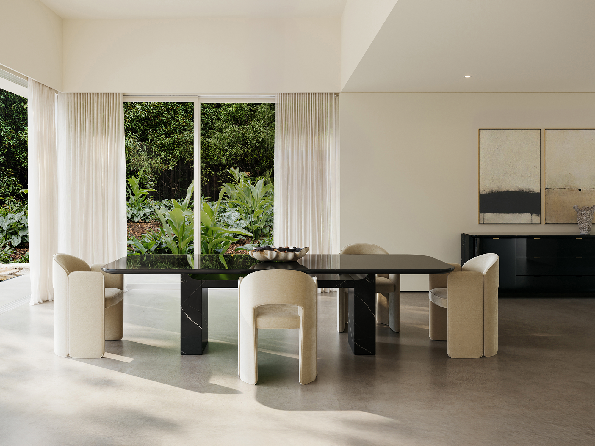 Caracole Classic — modern Overlap rectangular dining table featuring a high-sheen Piano Black top with gold spline accents, supported by two massive Nero Marquina marble pedestal bases, paired with cream upholstered sculptural dining chairs.