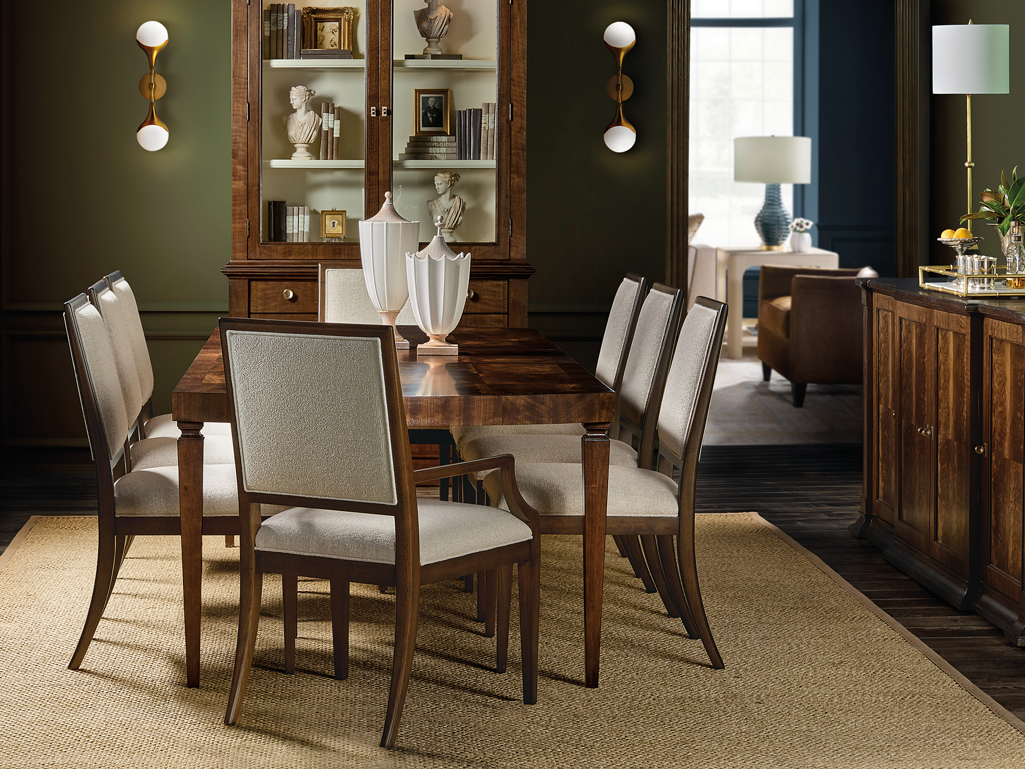Hooker Furniture — Archives collection traditional dining room featuring a figured walnut rectangular table and upholstered chairs paired with a matching display cabinet and buffet.