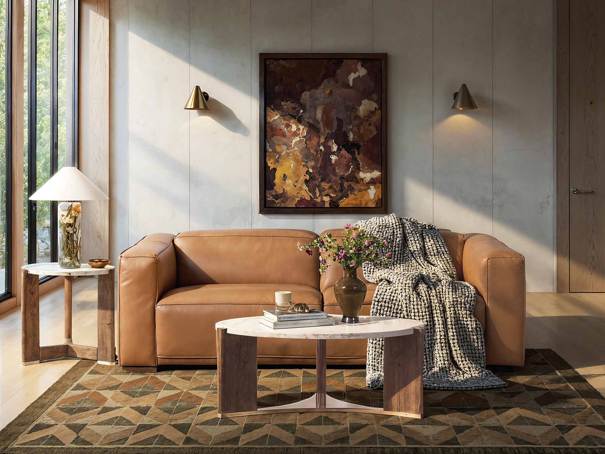 Hooker Furniture Eleana — warm modern living room featuring a cognac leather block sofa, white marble-top oval coffee table with wood accents, and a geometric patterned rug.