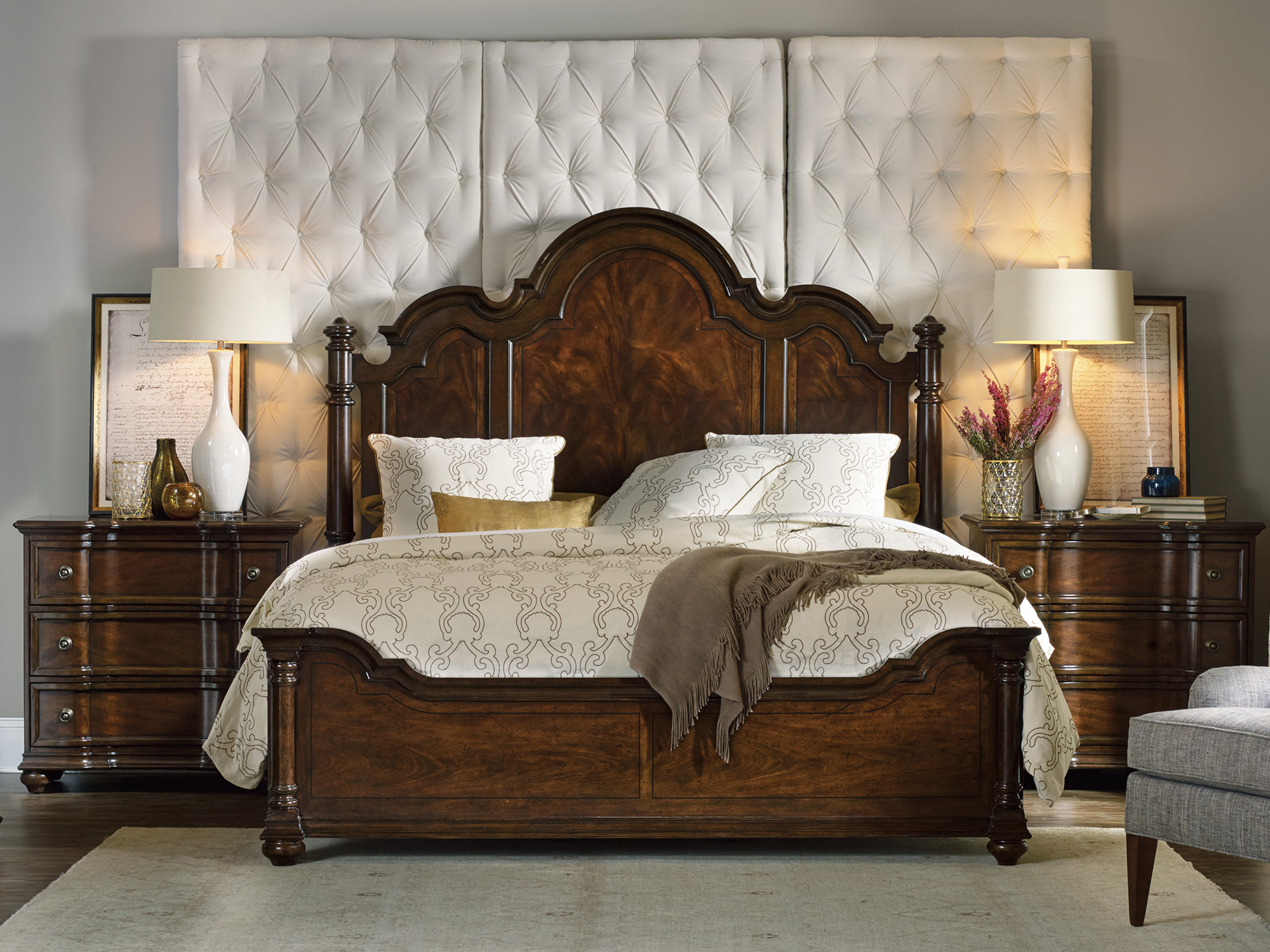 Hooker Furniture Leesburg — grand traditional bedroom featuring a cathedral-style mahogany poster bed, bombe-shaped nightstands, and a dramatic three-panel tufted wall headboard.