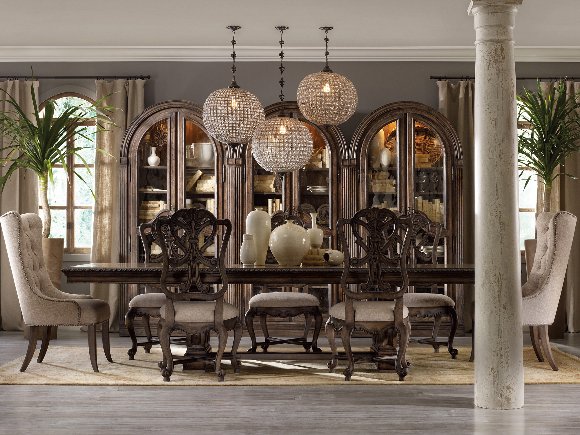 Hooker Furniture Rhapsody — opulent European traditional dining room featuring an expansive pedestal table, scroll-back chairs with cabriole legs, and three massive arched-top display cabinets.