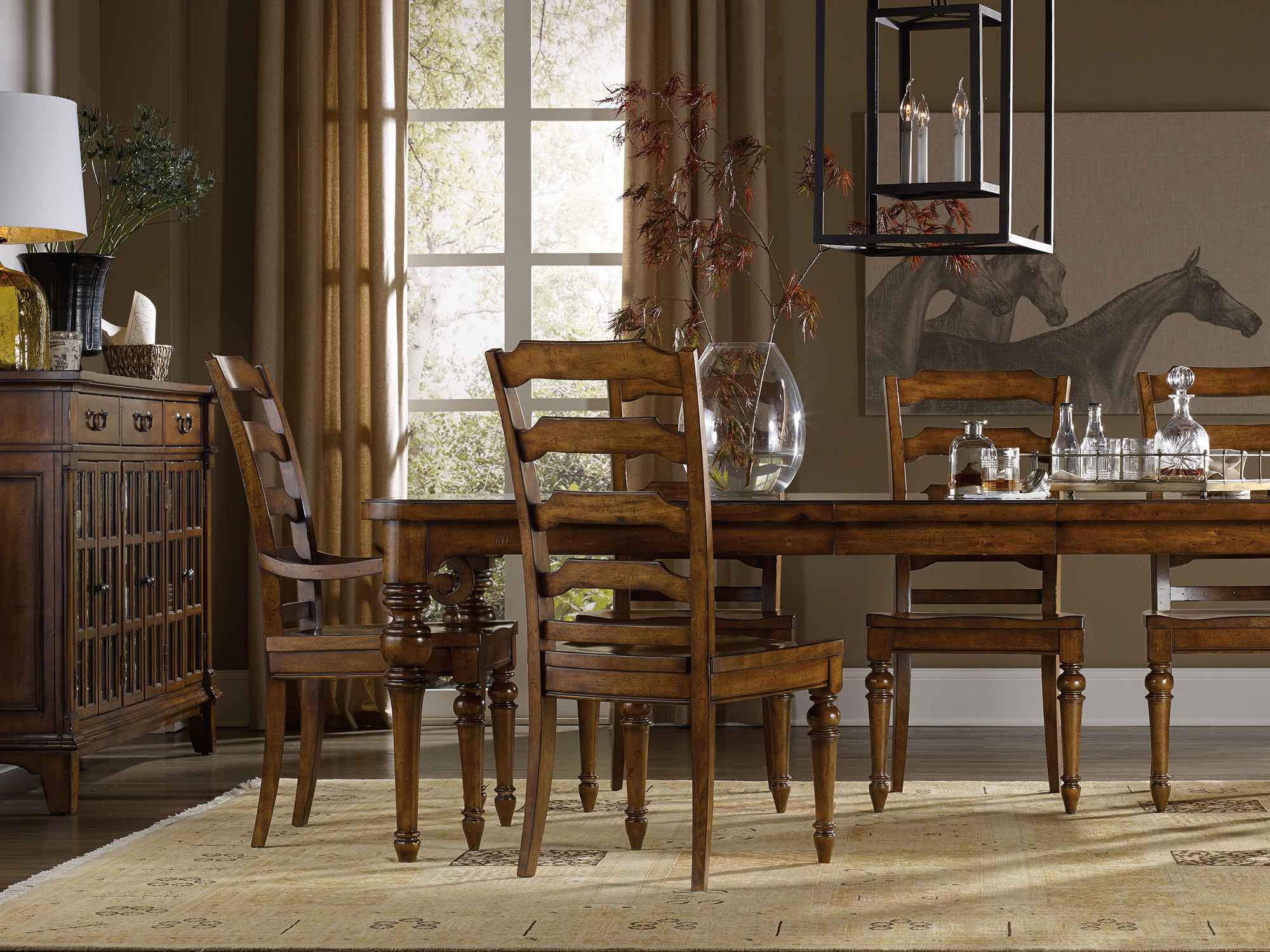 Hooker Furniture Tynecastle — stately equestrian-inspired dining room featuring a warm poplar and alder wood table with carved corbel accents, ladder-back chairs, and an architectural window-pane sideboard.