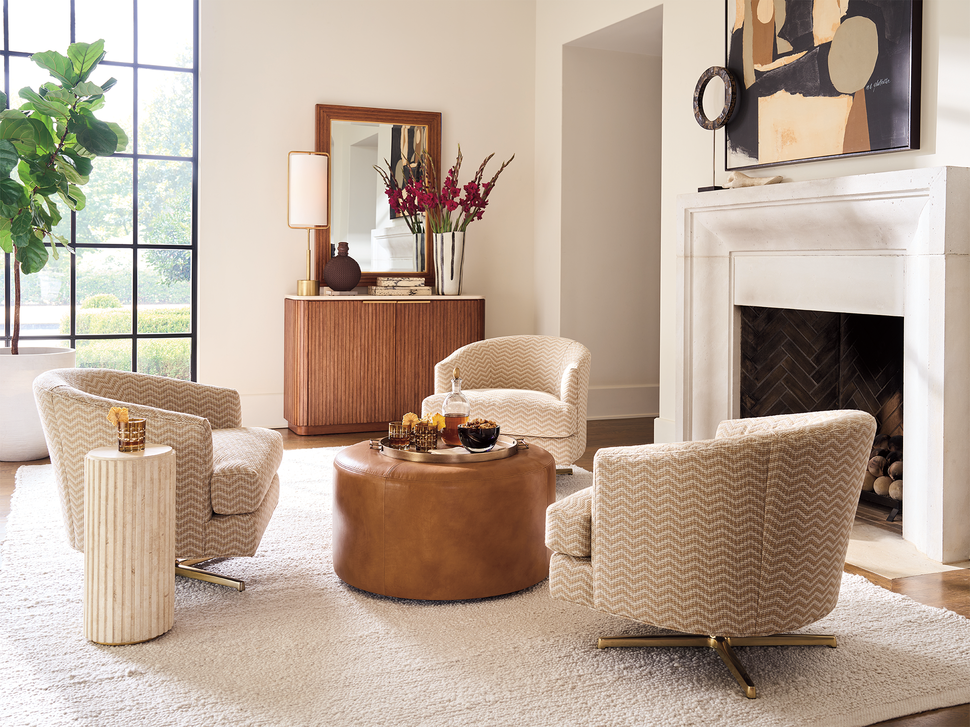 Lexington La Costa — chevron-upholstered swivel chairs, round leather ottoman, fluted stone side table, and ribbed wood credenza with brass-framed mirror