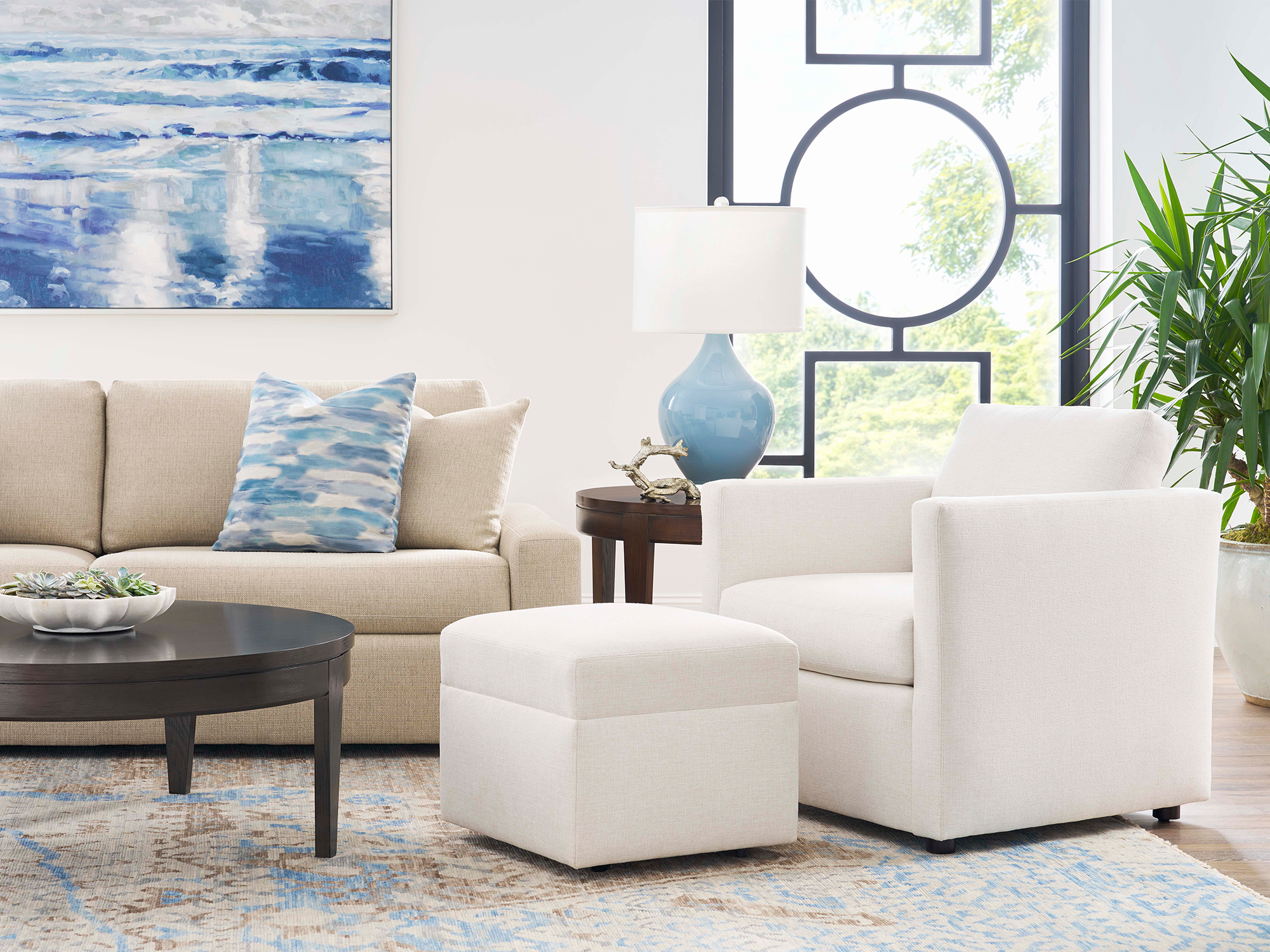 Sherrill Truman — sophisticated traditional living room featuring a classic cream tuxedo-style sofa with deep button tufting, paired with a matching tufted armchair and a dark wood cocktail table on a neutral patterned rug.